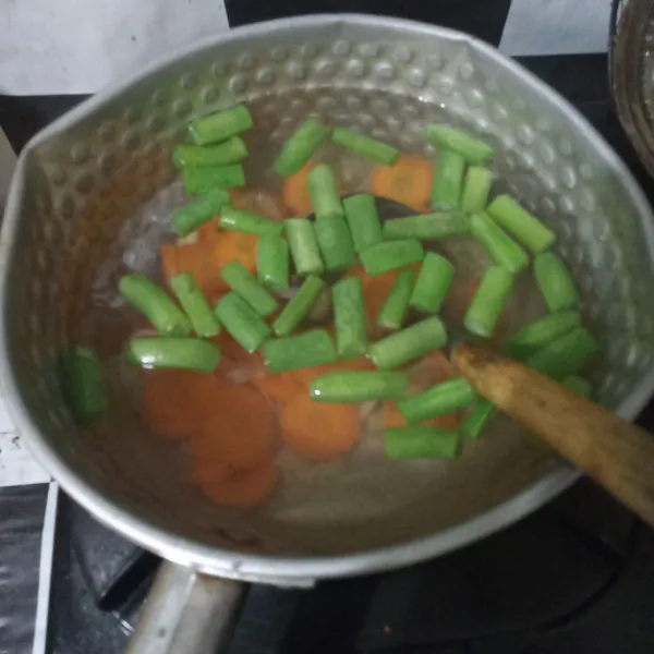 Masukkan buncis dan wortel, masak hingga setengah matang.