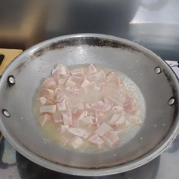 Tumis bawang putih yang sudah di cincang sampai harum, lalu masukkan ayam dan beri air secukupnya.