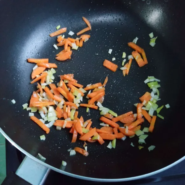 Panaskan sedikit minyak, tumis bawang bombai hingga wangi lalu masukkan wortel.