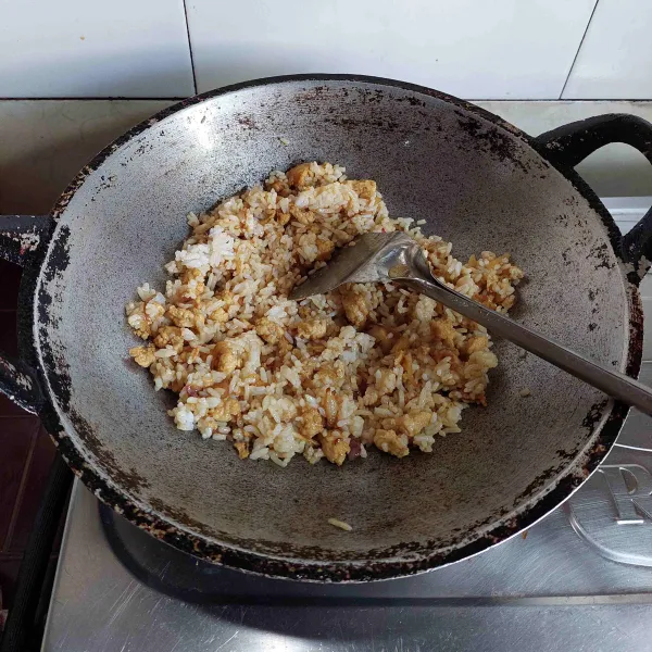 Selanjutnya masukan nasi, aduk hingga bumbu tercampur rata.