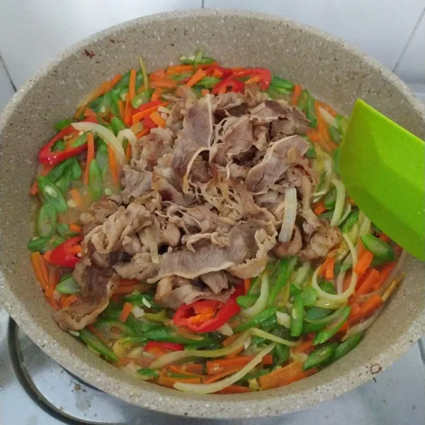 Tambahkan tumisan daging slice, aduk rata.