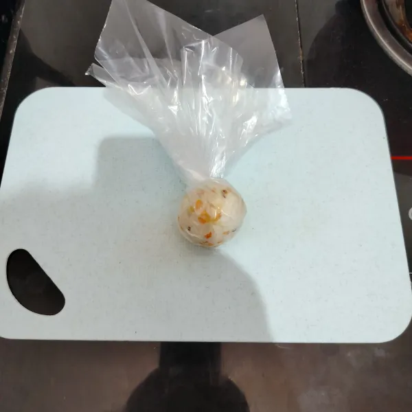 Lalu ambil 2 sdm nasi, letakkan di atas plastik, kemudian kepal-kepal bentuk bola.