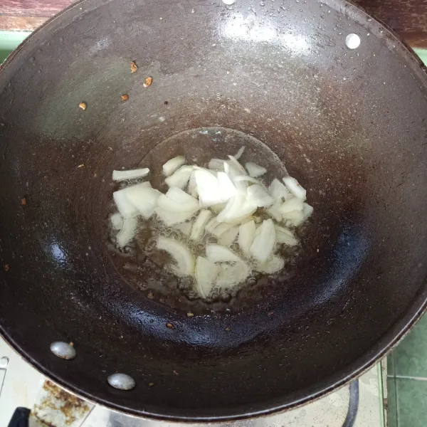 Siapkan wajan, lalu oseng irisan bawang bombay sampai tercium harum.