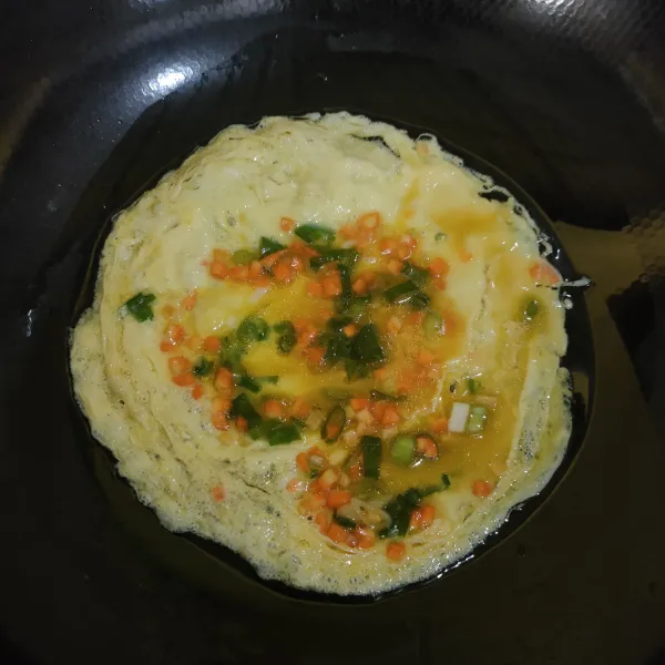 Tuang sedikit kocokan telur ke dalam teflon, lalu gulung telur.