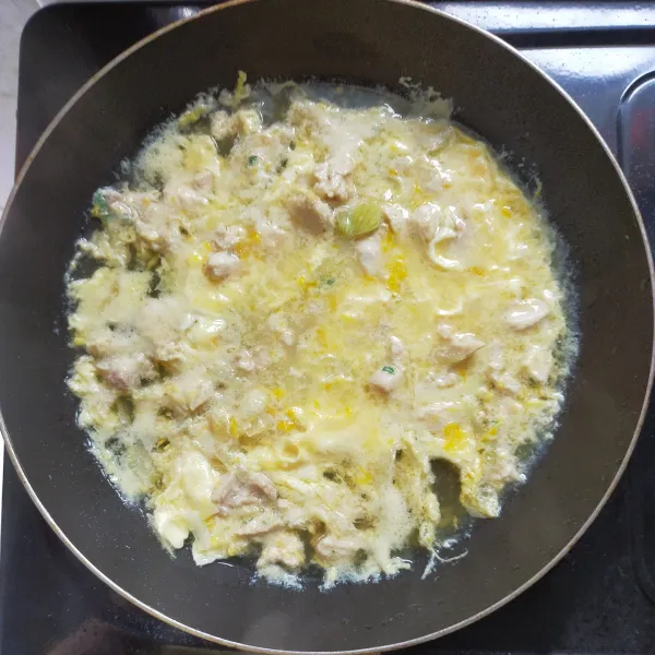 Tutup dengan tutup panci, ketika setengah matang taburi daun bawang, tutup kembali, masak hingga telur matang.