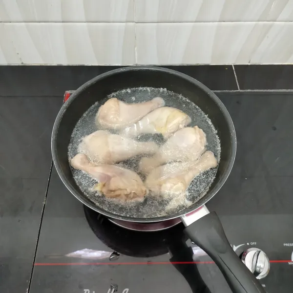 Cuci bersih paha ayam, lalu rebus dengan secukupnya air hingga mendidih. Kemudian tiriskan ayam dan buang air rebusannya.