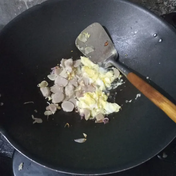 Masukkan telur, buat orak-arik lalu tambahkan irisan bakso. Aduk rata.
