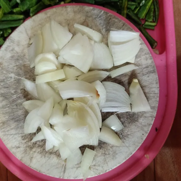 Kupas kulit bawang bombay, lalu iris tipis-tipis.
