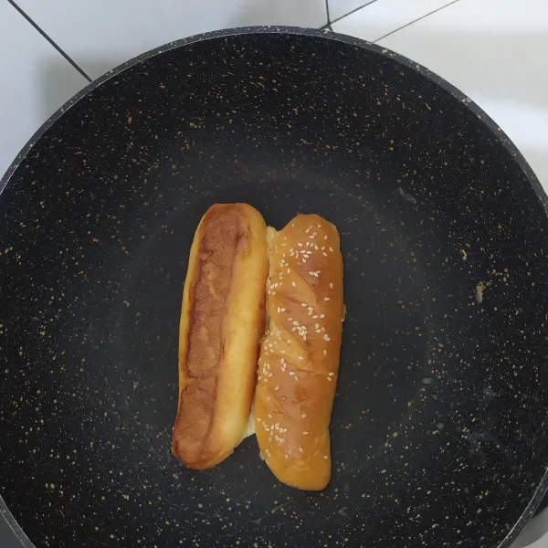 Belah menjadi 2 bagian hotdog bun nya, lalu olesi dengan butter bagian tengah nya dan grill hingga kecoklatan lalu angkat