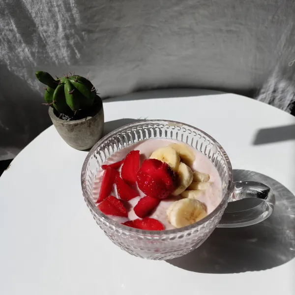 Beri potongan pisang strawberry di atas. Tuang yogurt.