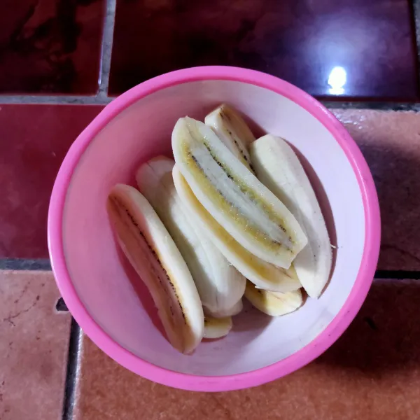 Kupas pisang, kemudian belah menjadi 2.