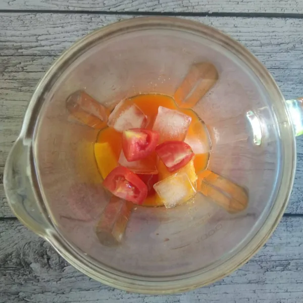 Masukkan jus wortel, tomat, pepaya, es batu dan madu ke dalam blender. Proses blender hingga halus.