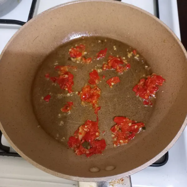 Haluskan cabe rawit cabe merah keriting dan bawang putih kemudian tumis hingga harum.