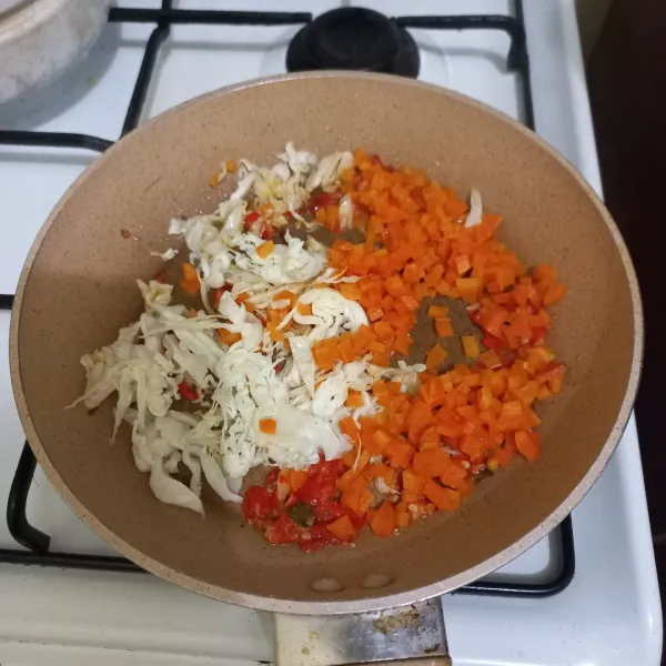 Masukan irisan kol dan wortel, aduk rata, tambahkan garam dan kaldu jamur, masak hingga matang, sisihkan.