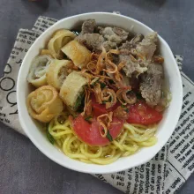Penyajian : tata mie kuning, bihun, kol, risol bihun, tomat, seledri, lalu tuang juah soto yang masih panas beserta potongan daging, lalu taburi bawang goreng, nikmati bersama perasan jeruk limau, sambal, dan kecap manis.