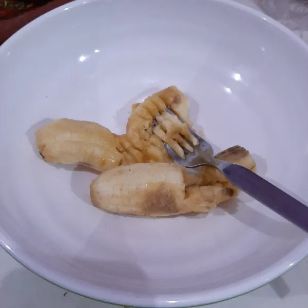 Lumatkan pisang dengan garpu.