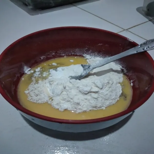 Kocok telur, tambahkan tepung terigu, tepung beras, baking powder, kunyit bubuk, lada bubuk dan kaldu, aduk dengan sendok hingga tercampur rata.