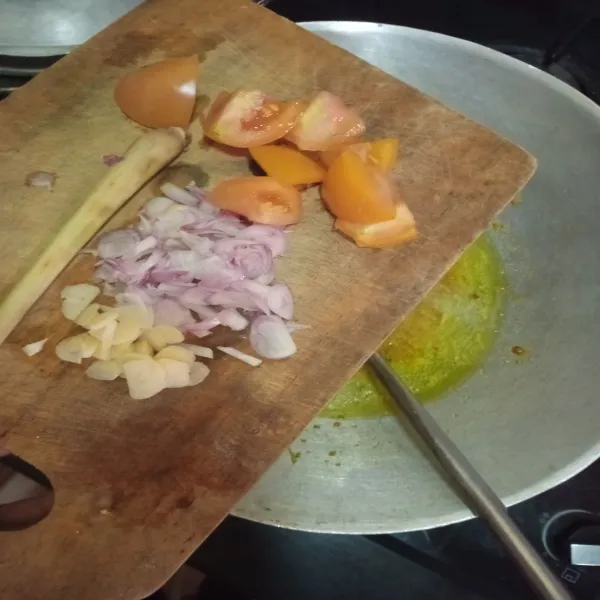 Lalu masukkan irisan bawang merah, bawang putih, serai dan tomat, aduk sampai agak mengental, lalu masukkan ke dalam panci yang berisi tetelan, aduk rata, masukkan santan instan.