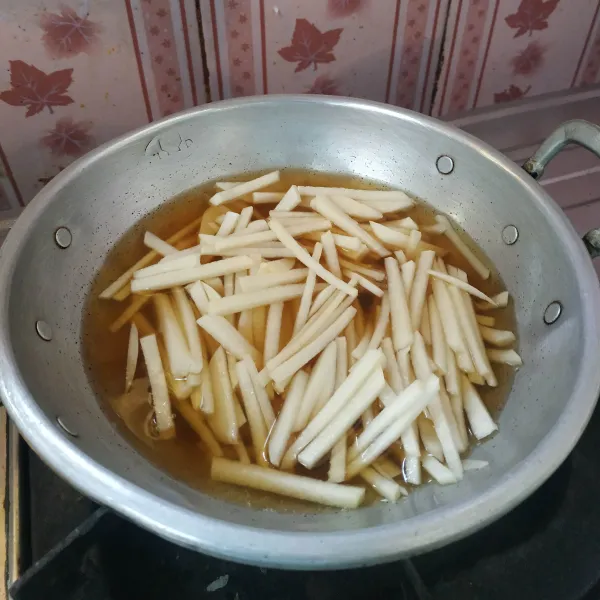 Rebus air dan gula merah hingga mendidih, setelah mendidih, masukkan bengkuang rebus hingga layu. Tiriskan bengkuang dan sisihkan terlebih dahulu.