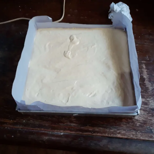 Olesi loyang 25 x 25 cm dengan margarin dan alasi kertas roti. Tuang adonan, ratakan dan hentak - hentakkan loyang.