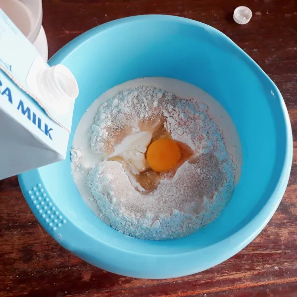 Campurkan terigu, ragi, telur, gula, dan susu kental manis. Tambahkan susu uht sedikit demi sedikit sambil diuleni hingga rata.