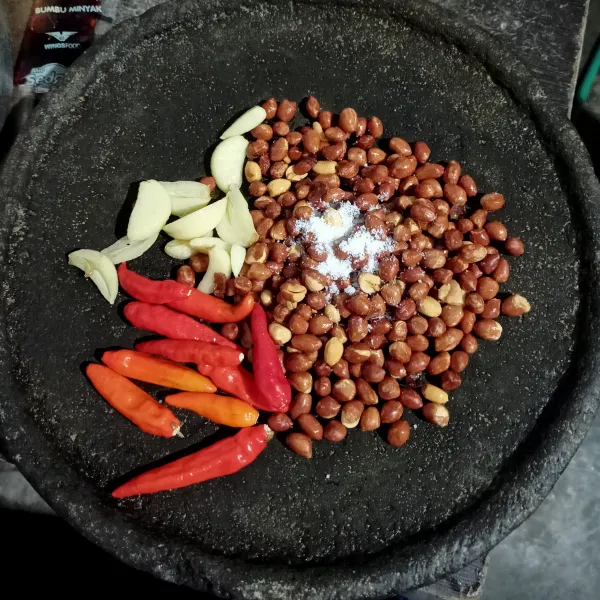 Haluskan kacang, bawang putih, cabe, garam.