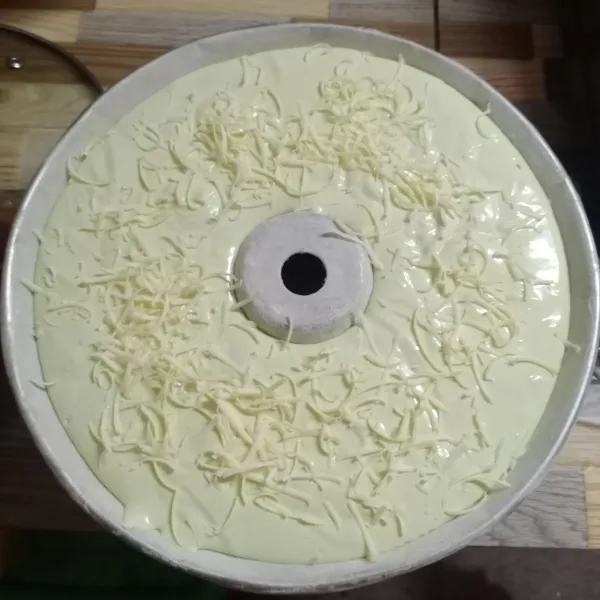 Tuang di loyang tulban ukuran 24 cm yang sudah dioles margarin dan ditabur tipis tepung terigu. Hentakkan beberapa kali lalu beri topping sesuai selera.