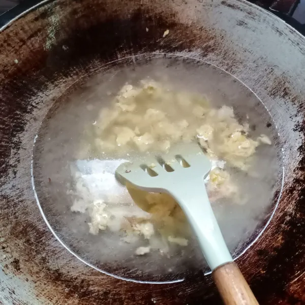 Masukkan telur, buat orak-arik. Kemudian masukkan air, masak sampai mendidih.