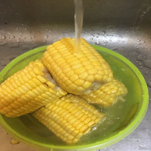 Cuci jagung menggunakan air bersih.