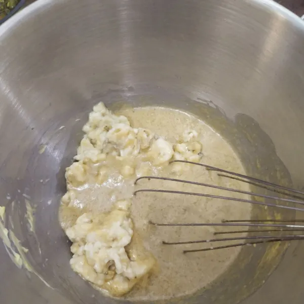 Kemudian masukkan pisang yang sudah dilumatkan, tambahkan telur dan vanili cair, aduk sampai rata.