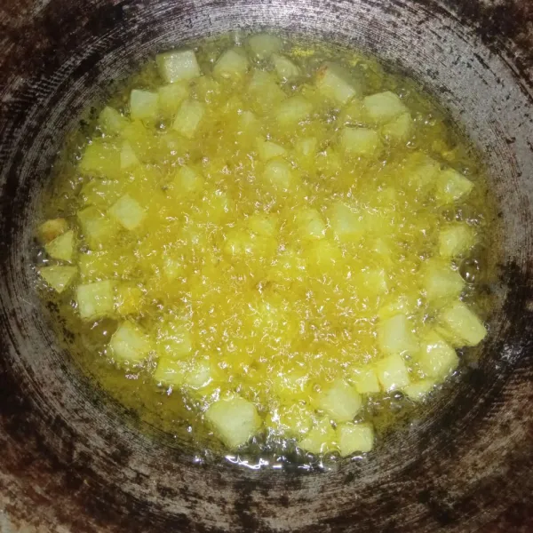 Kupas kentang, potong dadu kemudian cuci bersih. Goreng kentang di minyak panas hingga agak kering.
