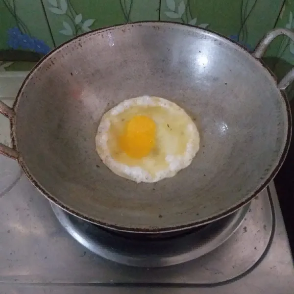Panaskan teflon, ceplok telur, taruh sedikit garam di atasnya.