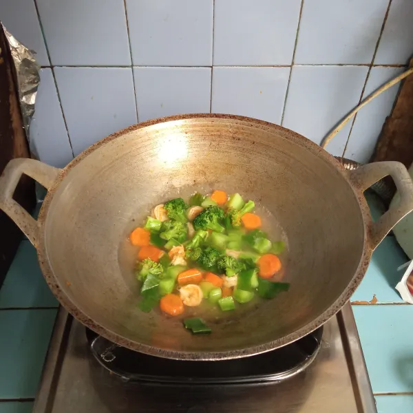 Masukkan potongan wortel dan bonggol brokoli, masak hingga setengah matang, lalu tambahkan brokoli dan daun bawang.