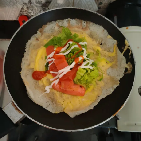 Setelah telur matang, masukkan selada, telur, beri saus dan mayonnaise, kemudian lipat kedua sisi.