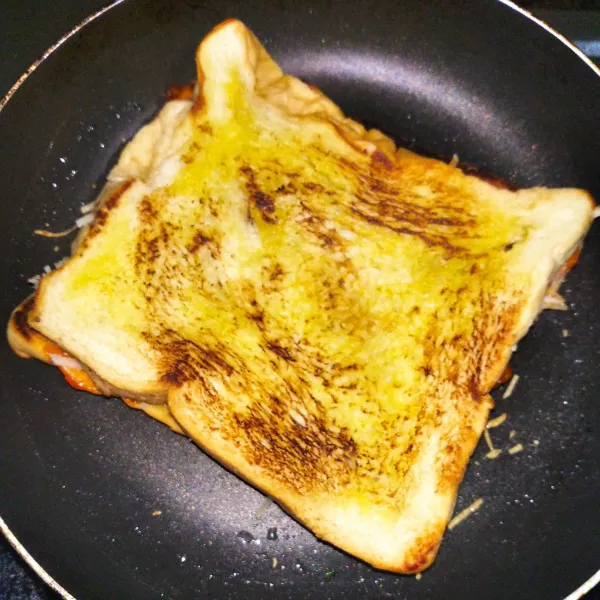 Tutup lagi dengan roti yang sudah di bakar, dan toast siap di sajikan.