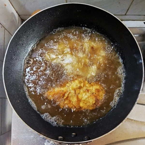 Goreng dada ayam yang sudah diberi tepung dalam minyak panas, masak hingga kering kecoklatan. Tiriskan.