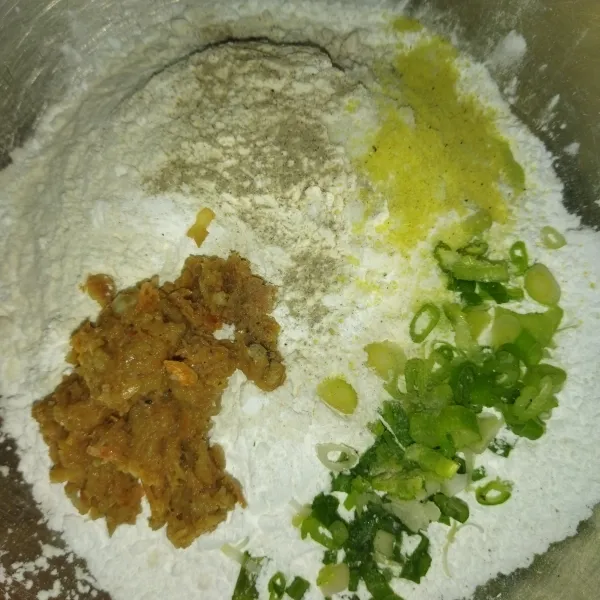 Siapkan wadah, masukkan tepung terigu, tepung sagu, daun bawang, kaldu bubuk, lada bubuk, garam dan bumbu yang tadi sudah dihaluskan, aduk rata.