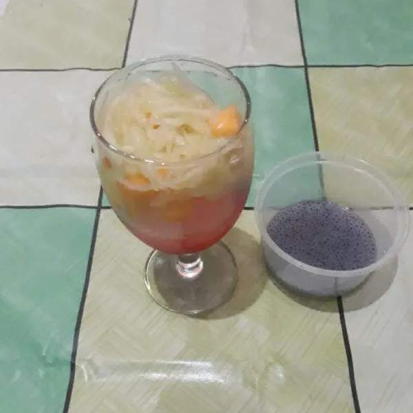 Masukkan potongan pepaya dan serutan melon ke dalam gelas.
