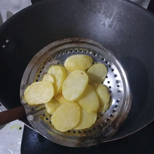 Kupas kentang dan iris, lalu cuci bersih. Kemudian goreng dan tiriskan.