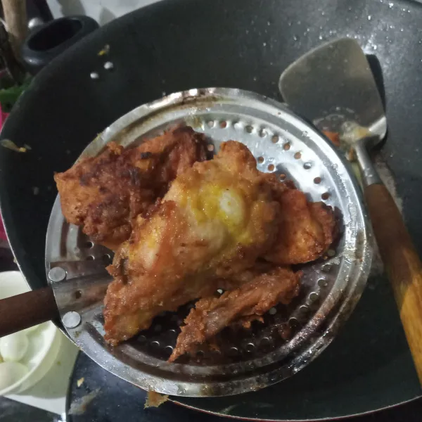 Goreng ayam dalam minyak panas, setelah ayam setengah matang masukkan bawang putih geprek. Goreng kembali hingga matang. Angkat dan tiriskan.