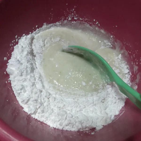 Pindahkan ke dalam wadah, tambahkan tepung tapioka sedikit demi sedikit ke adonan nasi, sambil di aduk agar tercampur rata dan uleni hingga membentuk adonan, jika adonan masih lengket di tangan, bisa di tambahkan tepung tapioka.
