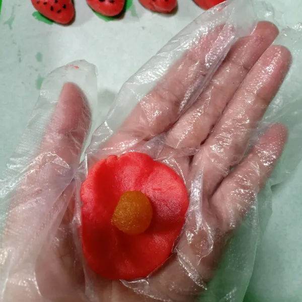 Ambil ±10 gr adonan strawberry, pipihkan lalu beri selai nanas. Bulantkan bentuk seperti strawberry.