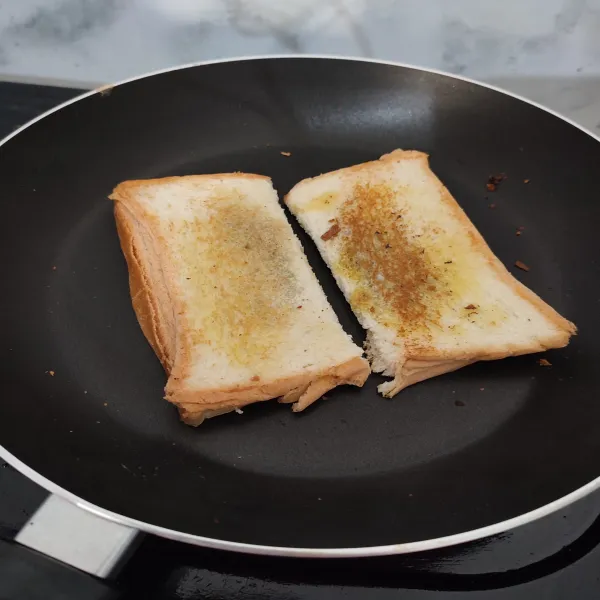 Panaskan teflon, beri margarin. Lalu panggang roti tawar hingga kecokelatan. Masak kedua sisi hingga matang, angkat dan sajikan.