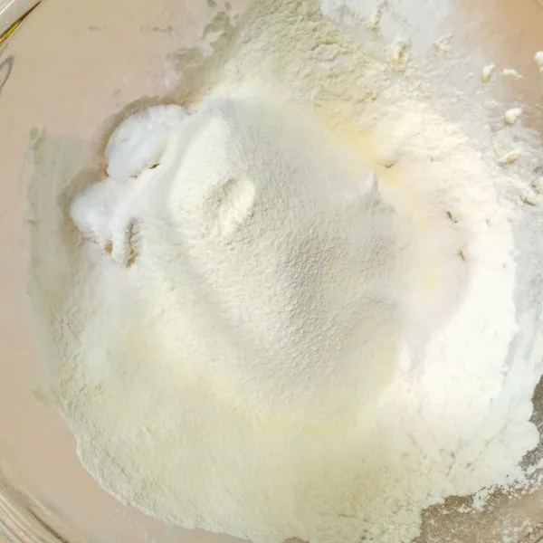 Tambahkan terigu, baking powder dan susu bubuk yang letah diayak. Kemudian aduk merata.