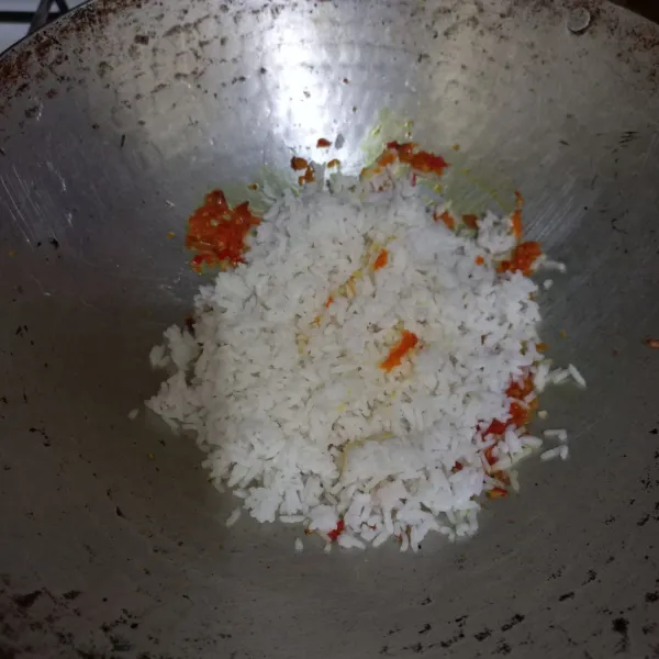 Masukan nasi pada wajan, tambahkan garam dan kaldu jamur, aduk rata.