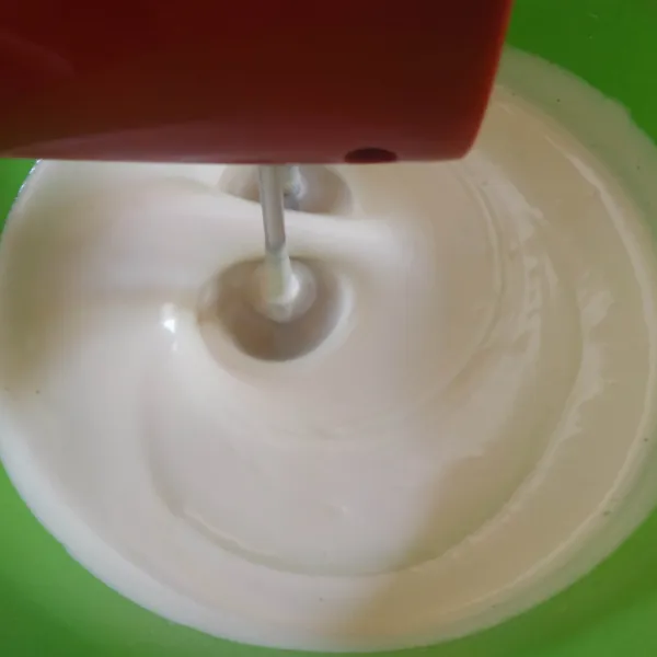 Turunkan kecepatan mixer ke speed sedang masukkan susu kental manis, mix hingga rata.