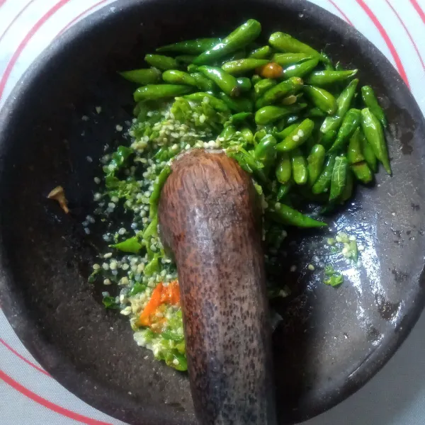 Uleng bawang putih bersama garam. Tambahkan cabe rawit yang digoreng tadi, tambahkan perasan limau dan bubuhi penyedap sesuai selera. Uleg sampai halus. Koreksi rasa.