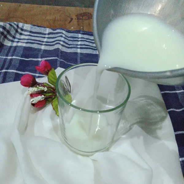 Larutkan susu kental manis dengan air kemudian tuang ke dalam gelas.