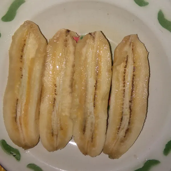Kupas pisang lalu belah menjadi 2 bagian.