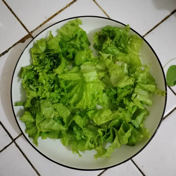 cuci bersih daun salad,iris lalu tata diatas piring salad
